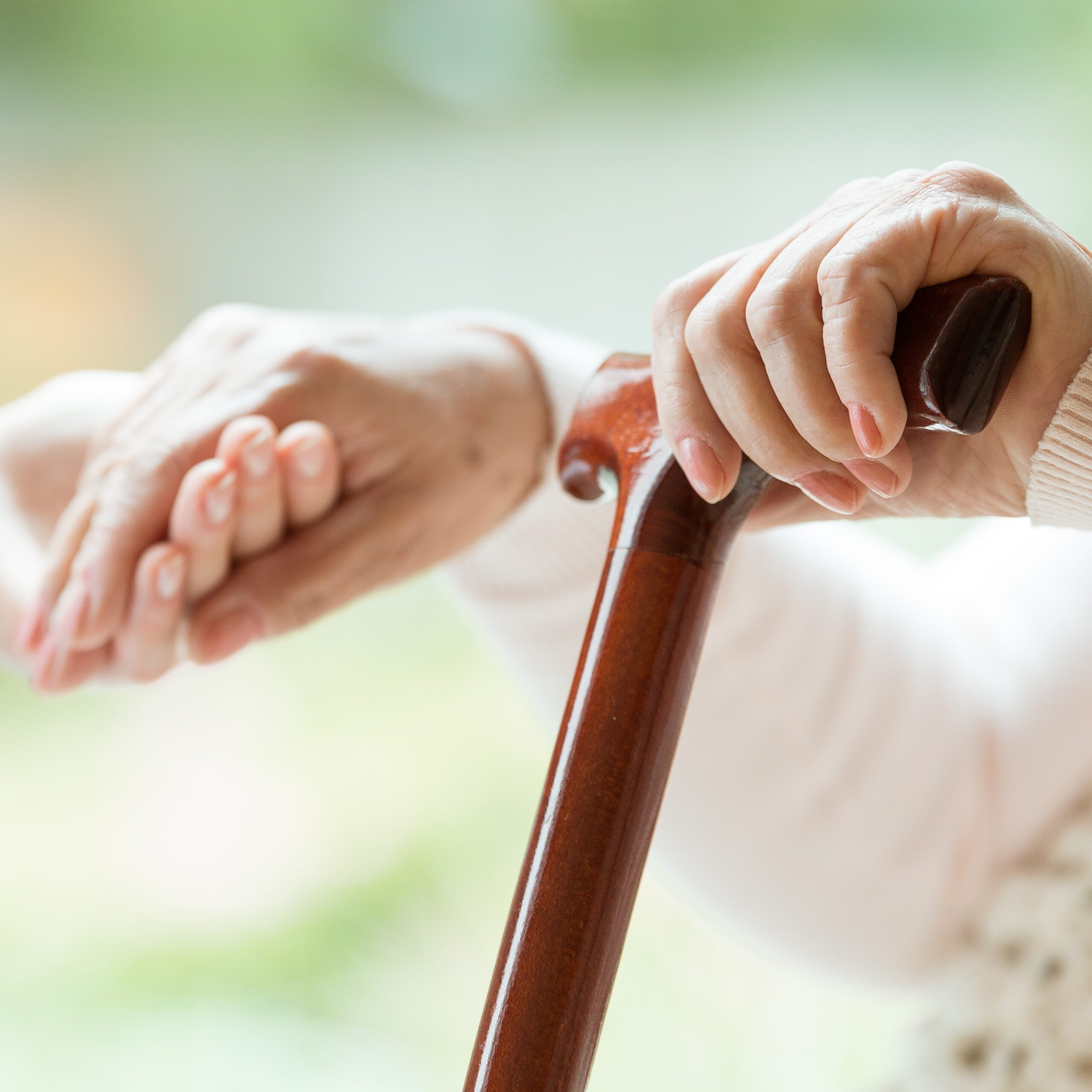 Elder,Person,Using,Wooden,Walking,Cane,During,Rehabilitation,In,Friendly
